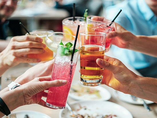 Fünf Menschen mit jeweils einem Cocktail in der Hand stoßen an